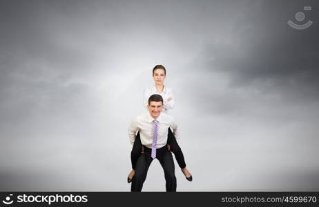 Let others work. Businesswoman riding on back of her colleague