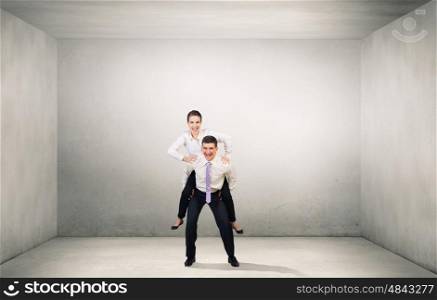 Let others work. Businesswoman riding on back of her colleague