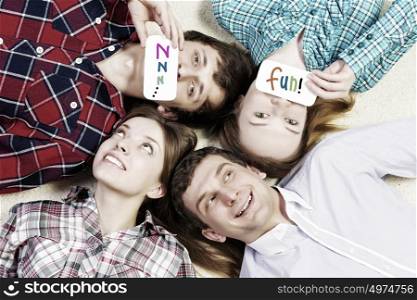 Let&rsquo;s be friends. Group of young smiling people lying on floor in circle with phone symbols