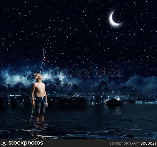 Let&rsquo;s go fishing. Boy of school age with fishing rod at night