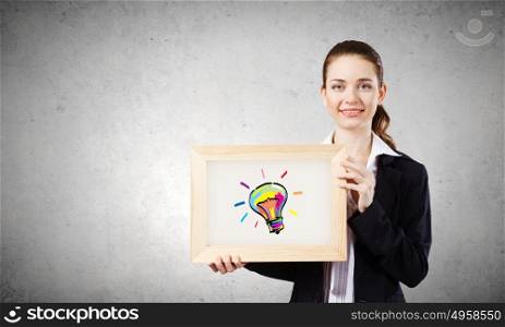 Let&rsquo;s think in colors. Young woman showing wooden frame with drawn bulb