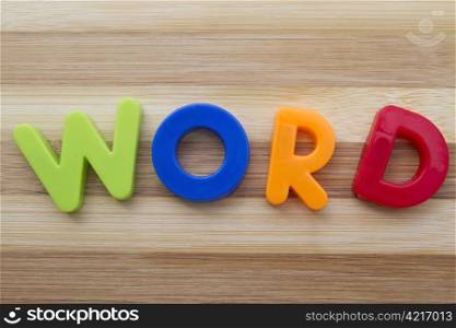 "Letter magnets "WORD" closeup on wood background "