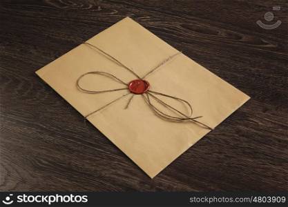 Letter with seal on table. Old post concept with envelope with wax seal on wooden surface