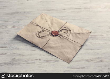 Letter with seal on table. Old post concept with envelope with wax seal on wooden surface