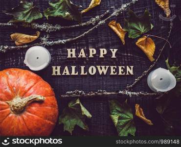 Letters of the alphabet in the form of the inscription Happy Halloween and ripe, bright pumpkins lying on a wooden surface. Close-up. Congratulations to loved ones, family, friends and colleagues. Letters of the alphabet and ripe pumpkin