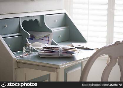 Letters tied with ribbon on writing desk