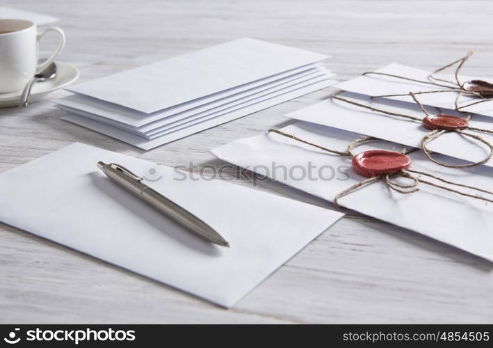 Letters with seal on table. Old post concept with envelope with wax seal and blank paper sheets on wooden surface