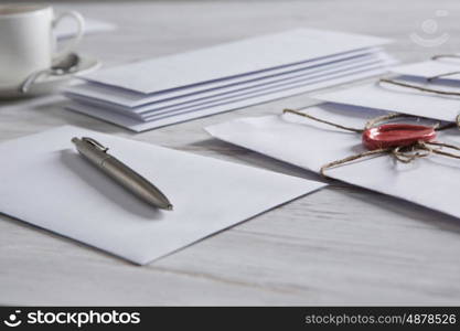 Letters with seal on table. Old post concept with envelope with wax seal and blank paper sheets on wooden surface