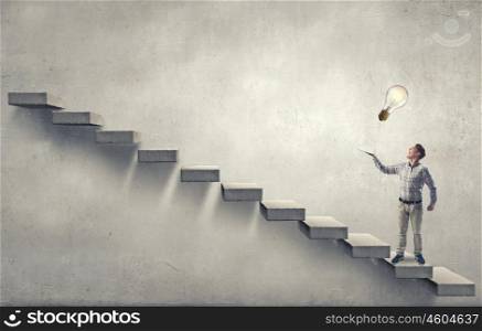 Level your knowledge. Young man running on steps reaching hand with book