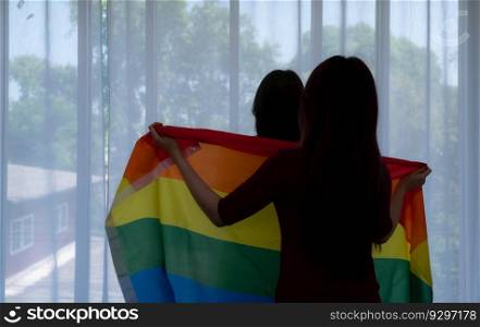 LGBT couples cover rainbow flags around their loved ones to keep warm and gaze out their hotel room windows together.