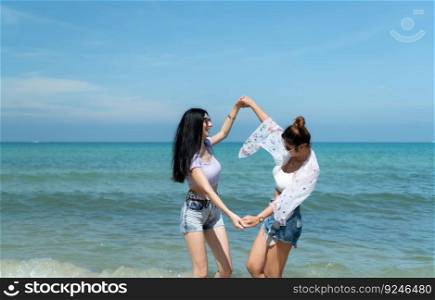 LGBT couples traveling around Asia, Swim happily on the sandy beach with the beautiful blue sea like paradise.