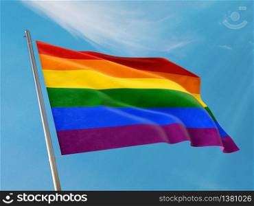 Lgbt flag on a pole waving. Lgbt realistic flag waving against clean blue sky. Close up. Photo stock