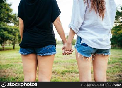 LGBT lesbian women couple moments happiness. Lesbian women couple together outdoors concept. Lesbian couple holding hands together relation fall in love. Two asian women having fun together at park.
