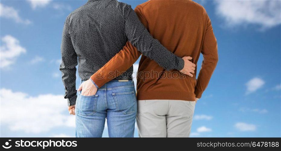 lgbt, same-sex relationships and homosexual concept - close up of hugging male gay couple over blue sky and clouds background. close up of hugging male gay couple. close up of hugging male gay couple