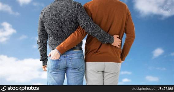 lgbt, same-sex relationships and homosexual concept - close up of hugging male gay couple over blue sky and clouds background. close up of hugging male gay couple. close up of hugging male gay couple