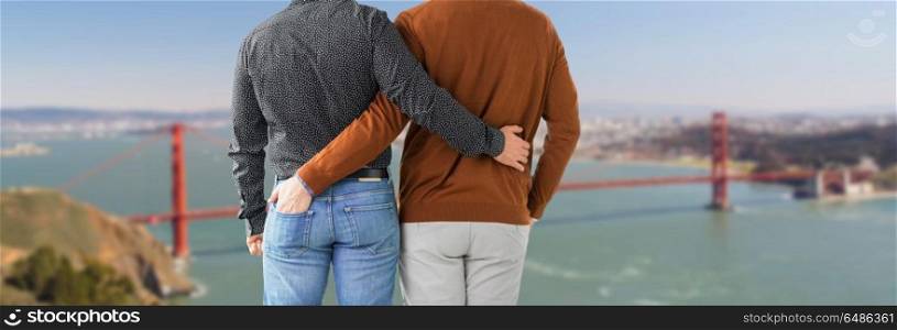 lgbt, same-sex relationships and homosexual concept - close up of hugging male gay couple over golden gate bridge in san francisco bay background. close up of male gay couple in san francisco. close up of male gay couple in san francisco