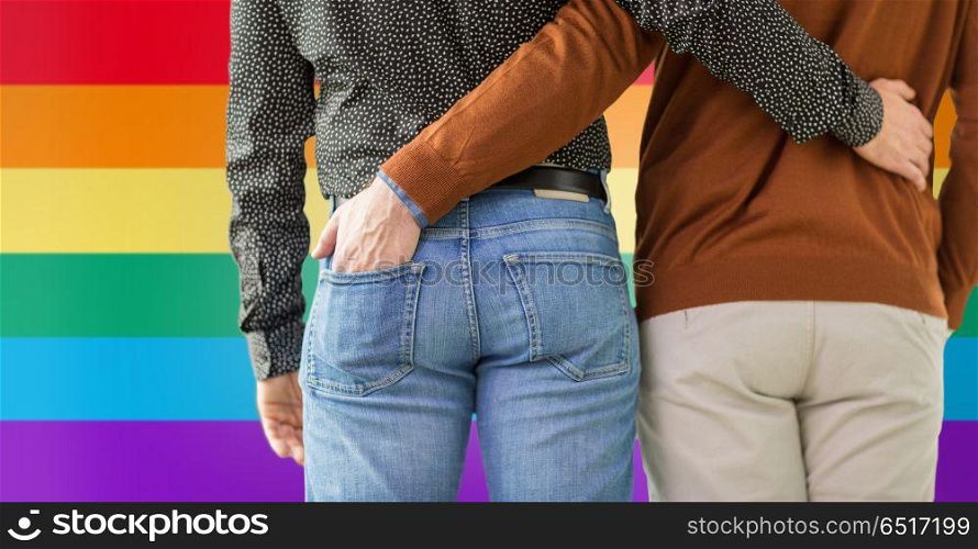 lgbt, same-sex relationships and homosexual concept - close up of hugging male gay couple over rainbow colors background. close up of hugging male gay couple. close up of hugging male gay couple
