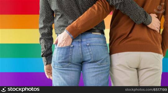 lgbt, same-sex relationships and homosexual concept - close up of hugging male gay couple over rainbow colors background. close up of hugging male gay couple. close up of hugging male gay couple