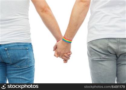 lgbt, same-sex relationships and homosexual concept - close up of male couple wearing gay pride rainbow awareness wristbands holding hands. male couple with gay pride rainbow wristbands. male couple with gay pride rainbow wristbands