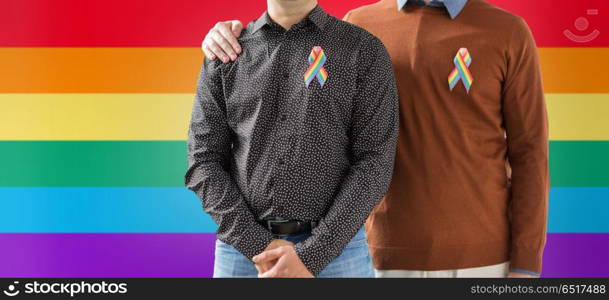 lgbt, same-sex relationships and homosexual concept - close up of male couple with gay pride rainbow awareness ribbons. close up of couple with gay pride rainbow ribbons. close up of couple with gay pride rainbow ribbons