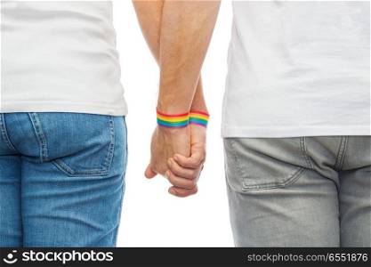 lgbt, same-sex relationships and homosexual concept - close up of male couple wearing gay pride rainbow awareness wristbands holding hands. male couple with gay pride rainbow wristbands. male couple with gay pride rainbow wristbands