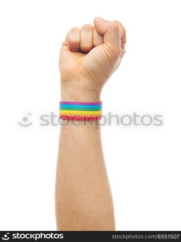 lgbt, same-sex relationships and homosexual concept - close up of male hand wearing gay pride awareness wristband showing fist. hand with gay pride rainbow wristband shows fist. hand with gay pride rainbow wristband shows fist