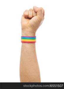 lgbt, same-sex relationships and homosexual concept - close up of male hand wearing gay pride awareness wristband showing fist. hand with gay pride rainbow wristband shows fist. hand with gay pride rainbow wristband shows fist