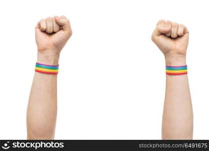 lgbt, same-sex relationships and homosexual concept - close up of male hands wearing gay pride awareness wristbands showing fist. hands with gay pride rainbow wristbands shows fist. hands with gay pride rainbow wristbands shows fist