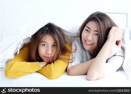 LGBT, Young cute asia lesbians lying and smiling on white bed together in the morning, couple lesbians happy moment