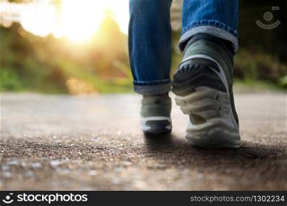 Life and Challenging Concept. Low Section of Motivated Young Man Walking in Outdoor. Natural Sunlight as background