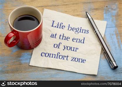 Life begins at the end of your comfort zone - inspirational handwriting on a napkin with a cup of coffee