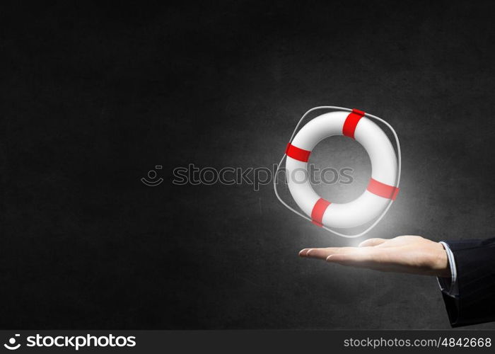 Life insurance concept. Hand of businessman on dark background holding lifebuoy