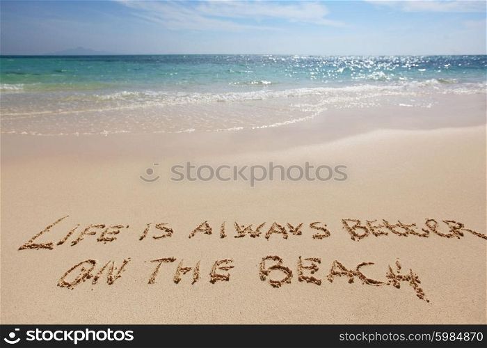 Life is always better on the beach, conceptual handwriting on sand