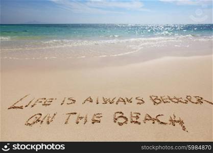 Life is always better on the beach, conceptual handwriting on sand