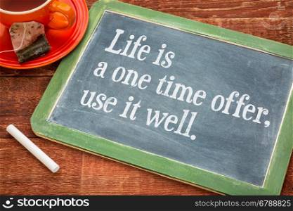Life is one time offer, use it well - motivational text on a slate blackboard with chalk and cup of tea