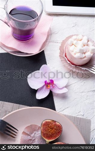 life style concept. Thai blue, Butterfly pea tea served with fresh figs and panna cotta cake and fruit piece of cake on serving napkins.