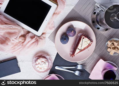 life style set at meeting in cafe.Thai blue, Butterfly pea tea served with fresh figs and panna cotta cake and fruit piece of cake on serving napkins. flat lay