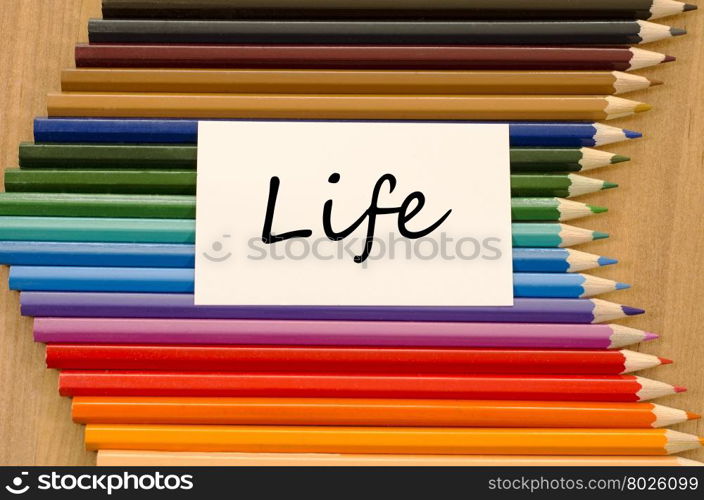Life text concept and colored pencil on wooden background