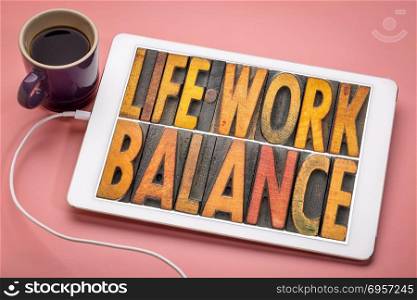 life work balance word abstract in letterpress wood type . life work balance - word abstract in vintage letterpress wood type on a digital tbalet with a cup of coffee