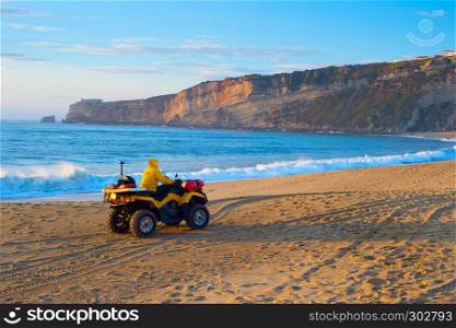 Lifeguard riding a buggy at the ocean beach at sunset. Nazare, Portugal