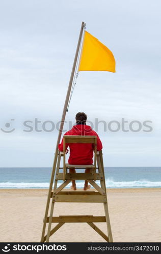 Lifeguard sitting in his chair watching the sea