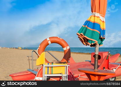 Lifeguard tools, umbrella,lifebuoy and rescue boat against beach,sea and sky