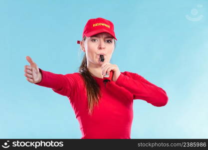 Lifeguard woman girl in red cap on duty supervising swimming pool water blowing whistle on blue. Accident prevention rescue.. Lifeguard woman in cap on duty blowing whistle.