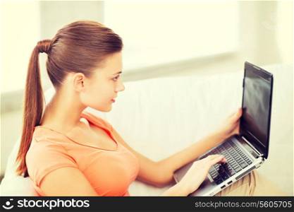 lifestyle and internet concept - woman using laptop at home