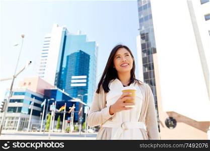 lifestyle and people concept - happy smiling young woman in sunglasses with takeaway coffee cup on city street. smiling woman with takeaway coffee cup in city