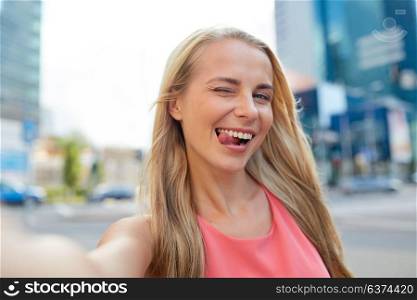 lifestyle and people concept - happy young woman taking selfie on city street. happy young woman taking selfie on city street
