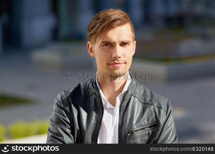 lifestyle and people concept - portrait of young man in leather jacket outdoors. portrait of young man in leather jacket outdoors