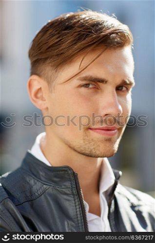 lifestyle and people concept - portrait of young man in leather jacket outdoors. portrait of young man in leather jacket outdoors