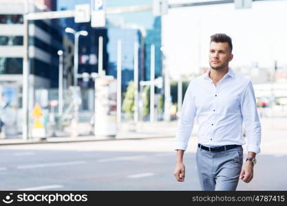 lifestyle and people concept - young man walking along city street. young man walking along city street