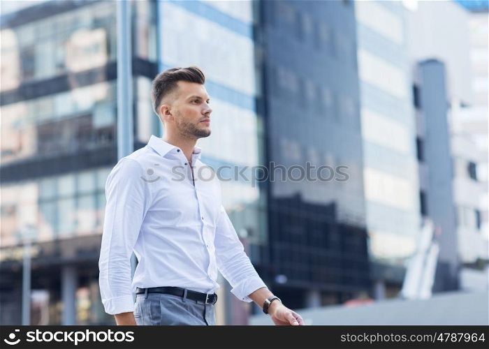 lifestyle and people concept - young man walking along city street. young man walking along city street
